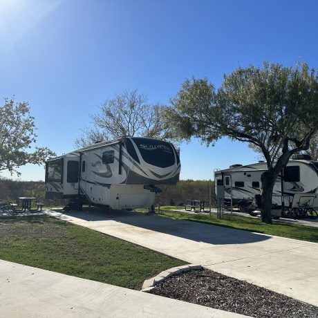 View of full hook-up sites with paved docks and RVs at Hidden Valley RV Park