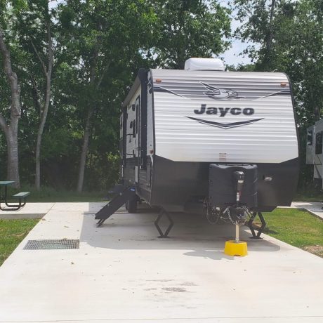 Jayco trailer backed into a concrete rv site.