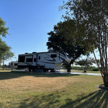Large RV site and huge yard with a fifth wheel backed into it.
