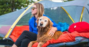 camping gal with her dog in front of her tent